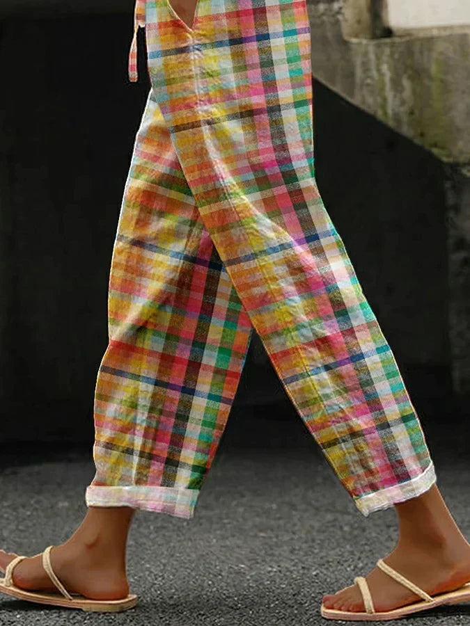  Woman showcasing classic checkered trousers styled for everyday wear on a plain background.