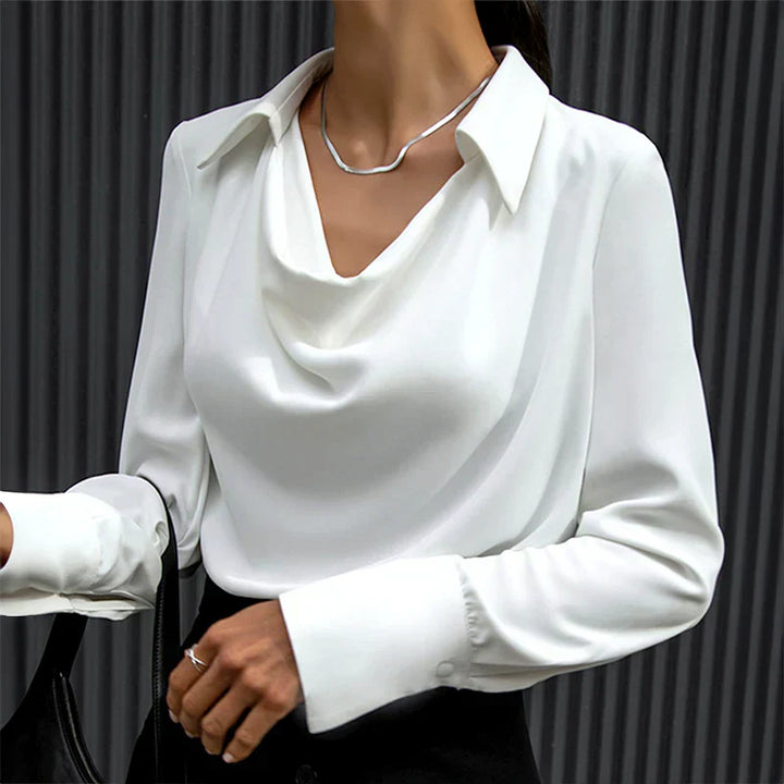 Female model wearing a dressy satin blouse for office styling on a plain background.
