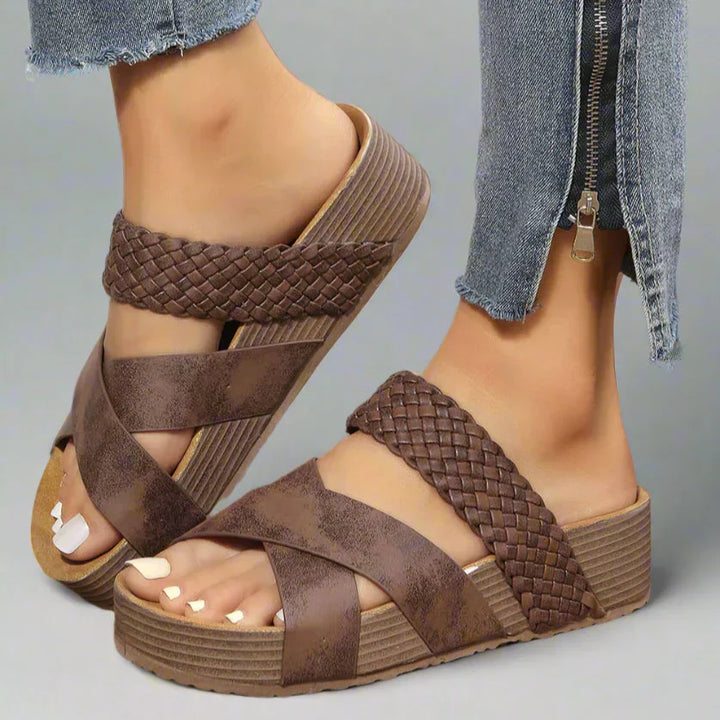 Woman wearing cushioned sandals with open-toe styling against a plain background.