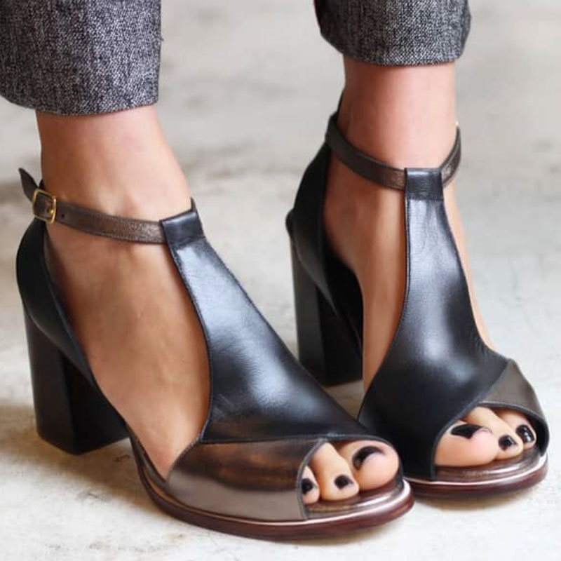 Woman wearing patchwork open-toe block heel sandals on a plain background.