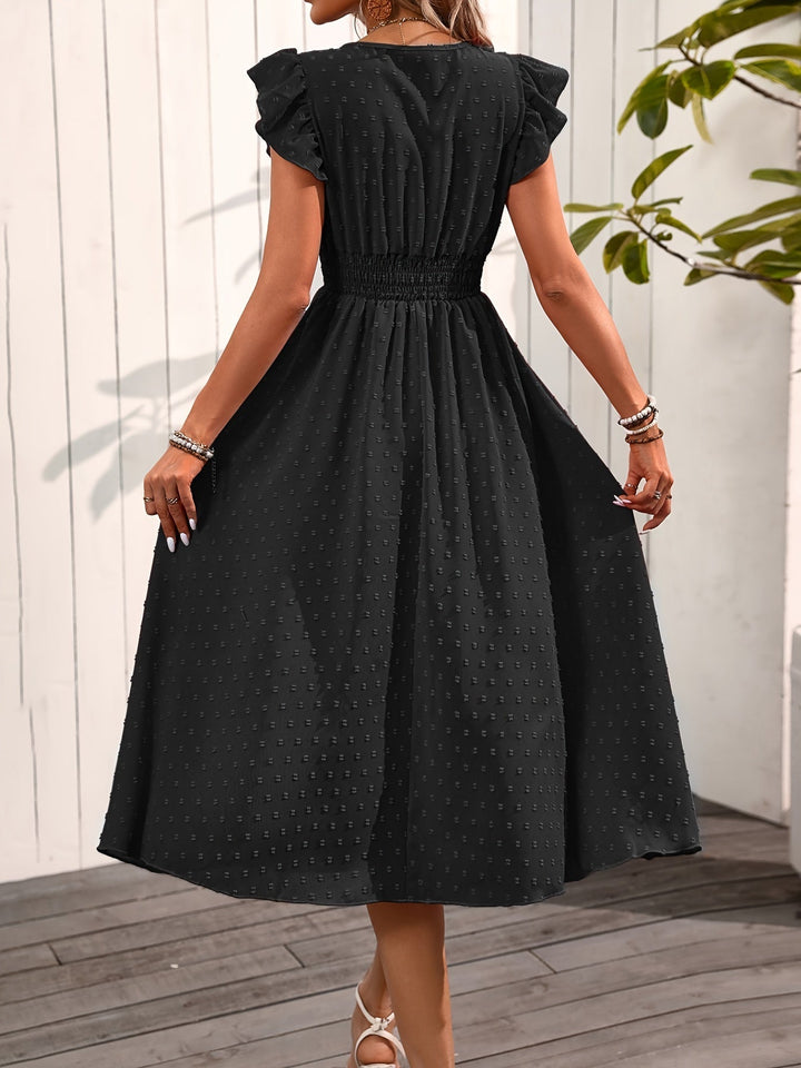Woman in a ruffle sleeve midi dress with an elegant and versatile silhouette on a plain background.