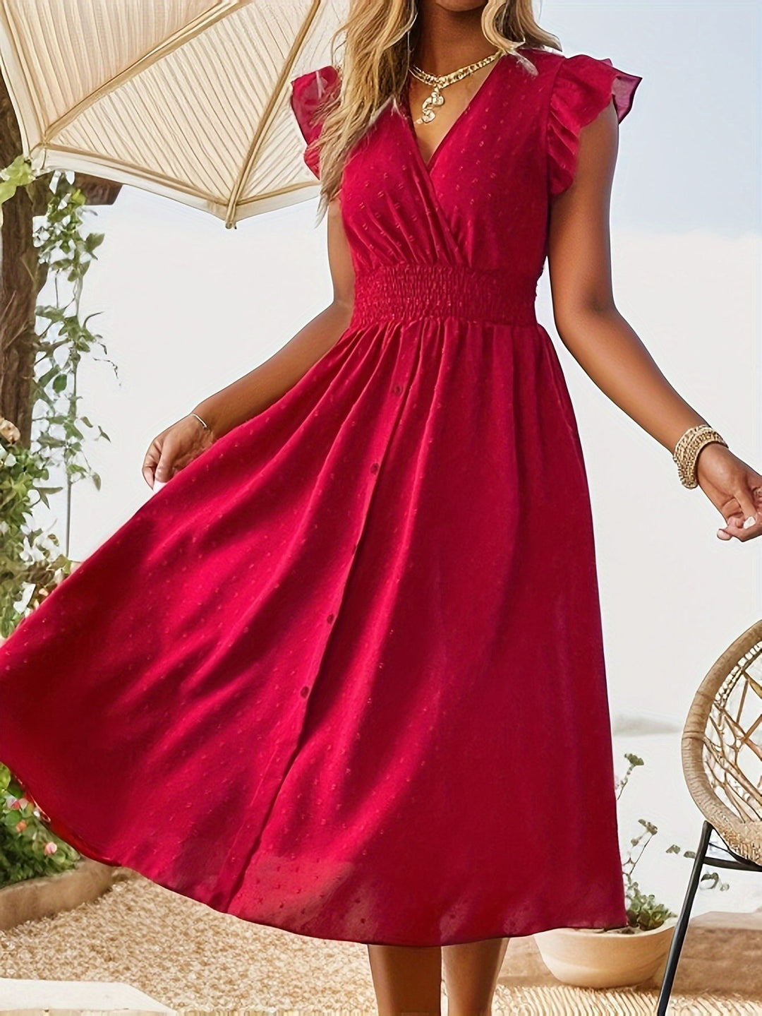  Woman displaying a feminine midi dress with a timeless spotted print on a plain background.