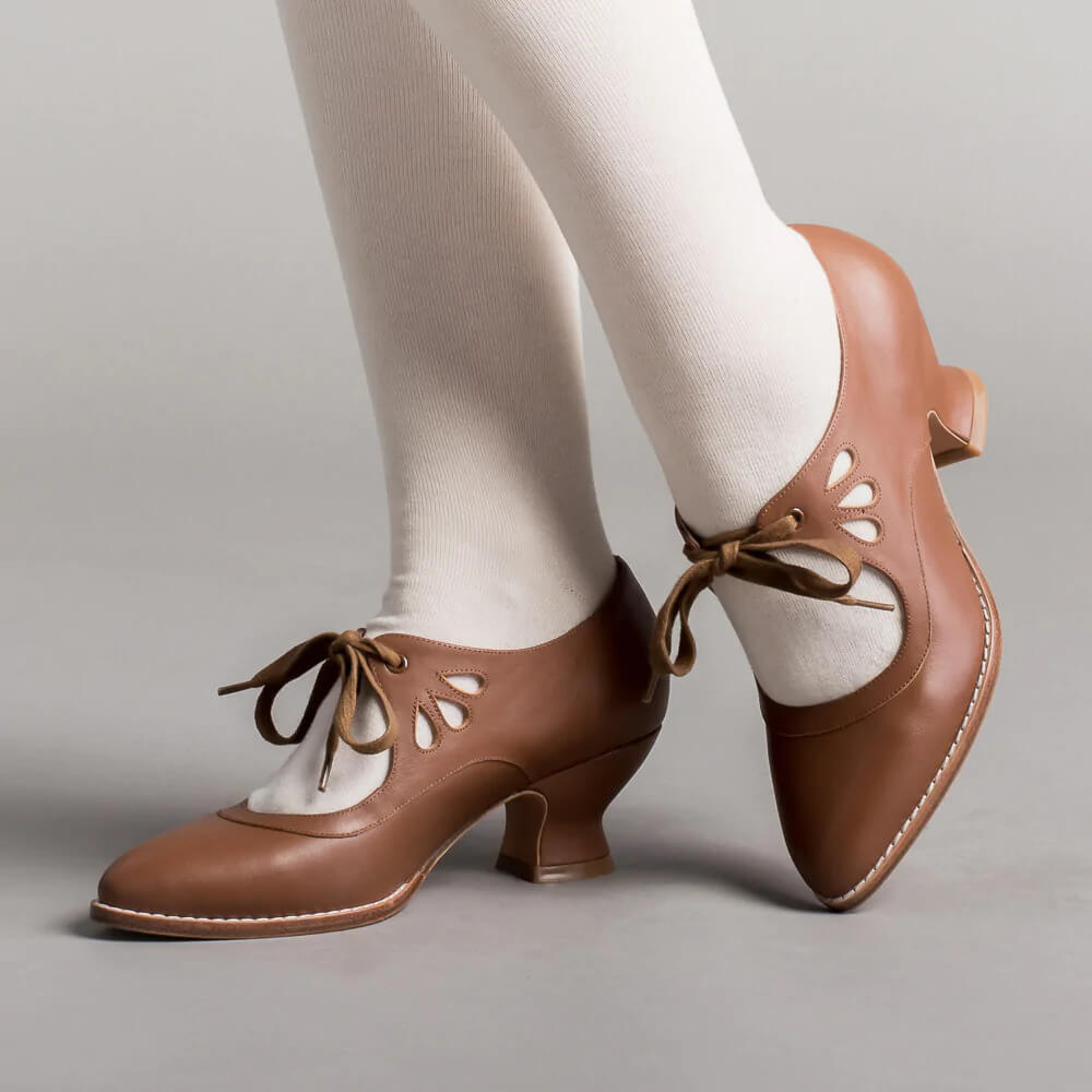 Model posing in ankle strap heels on a plain background.