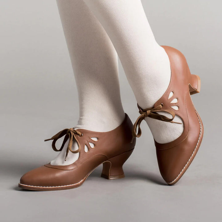 Model posing in ankle strap heels on a plain background.