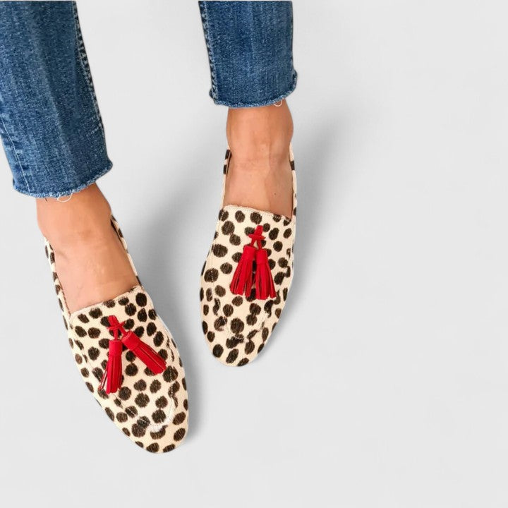 Female wearing sleek loafers on a plain background for everyday casual styling.
