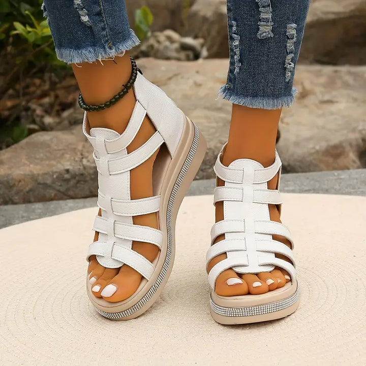Female modelling summer sandals with adjustable fastening and low heel.