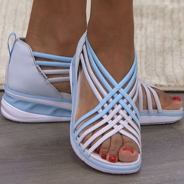 Female wearing supportive sandals on a plain background.