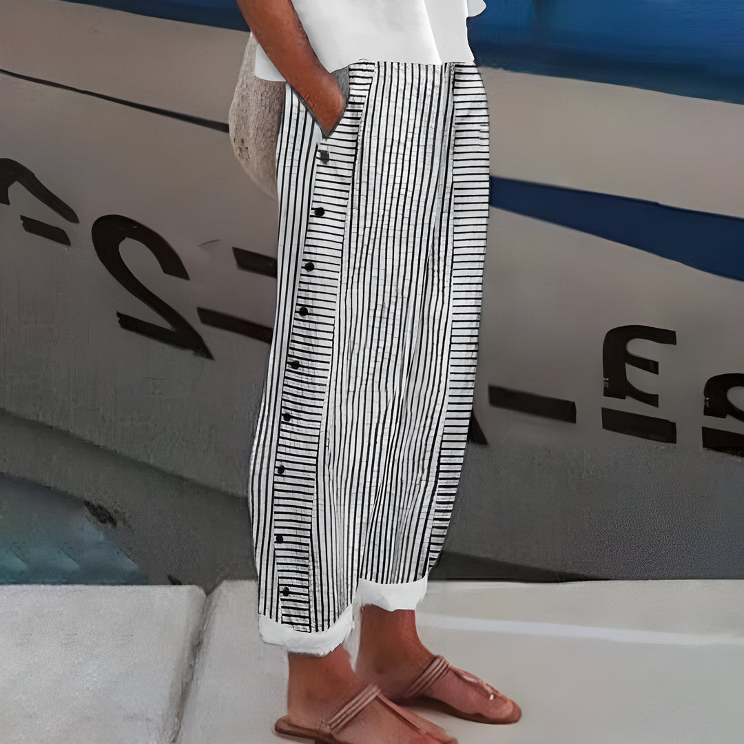  Female modelling relaxed fit striped trousers with pocket detail on a plain background.