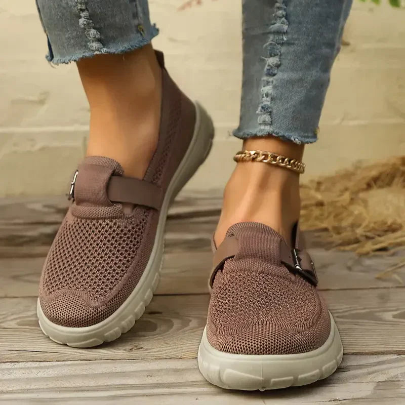 Female model wearing strap Mary Jane shoes on a plain background.