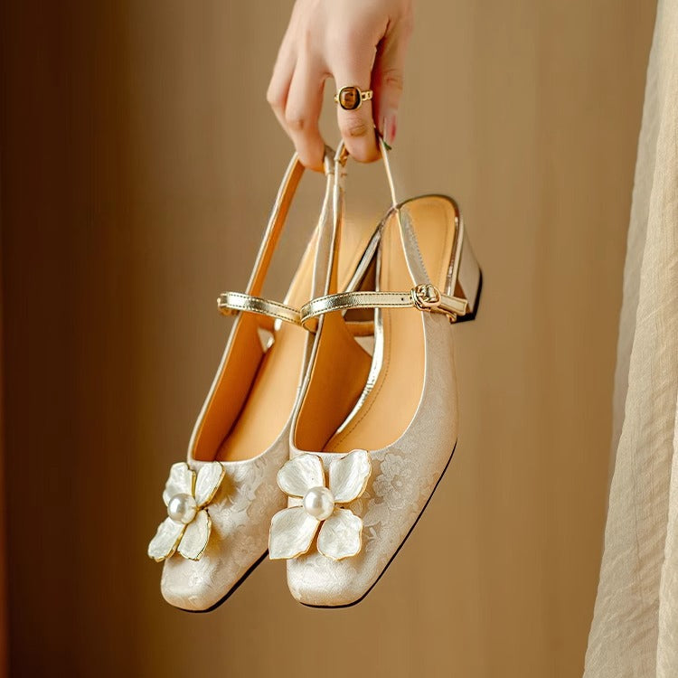 Female modelling square toe occasion heels on a plain background.