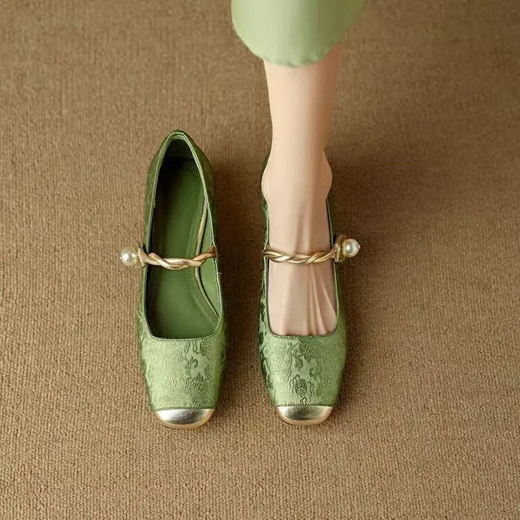 Female showcasing metallic toe cap Mary Jane shoes with a glitter heel on a plain background.