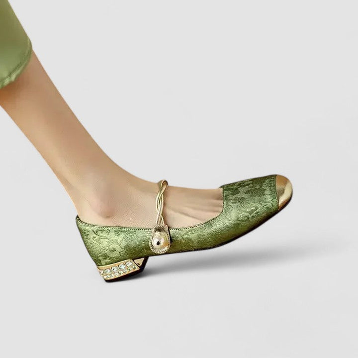 Female wearing low strap shoes with a rounded toe on a plain background.