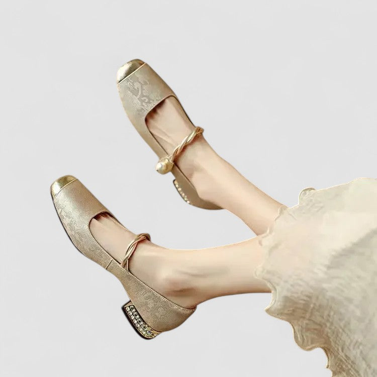 Female modelling closed toe strap shoes on a plain background.
