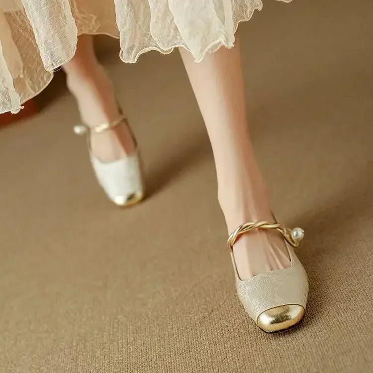 Female modelling vintage-style Mary Jane shoes with pearl detail on a plain 