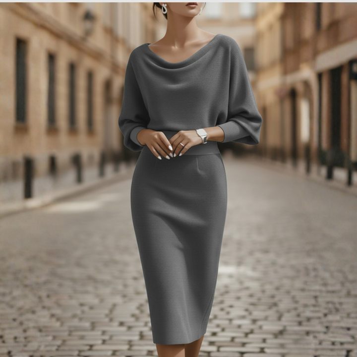 Female model wearing a cowl neck midi dress with batwing sleeves against a plain background.