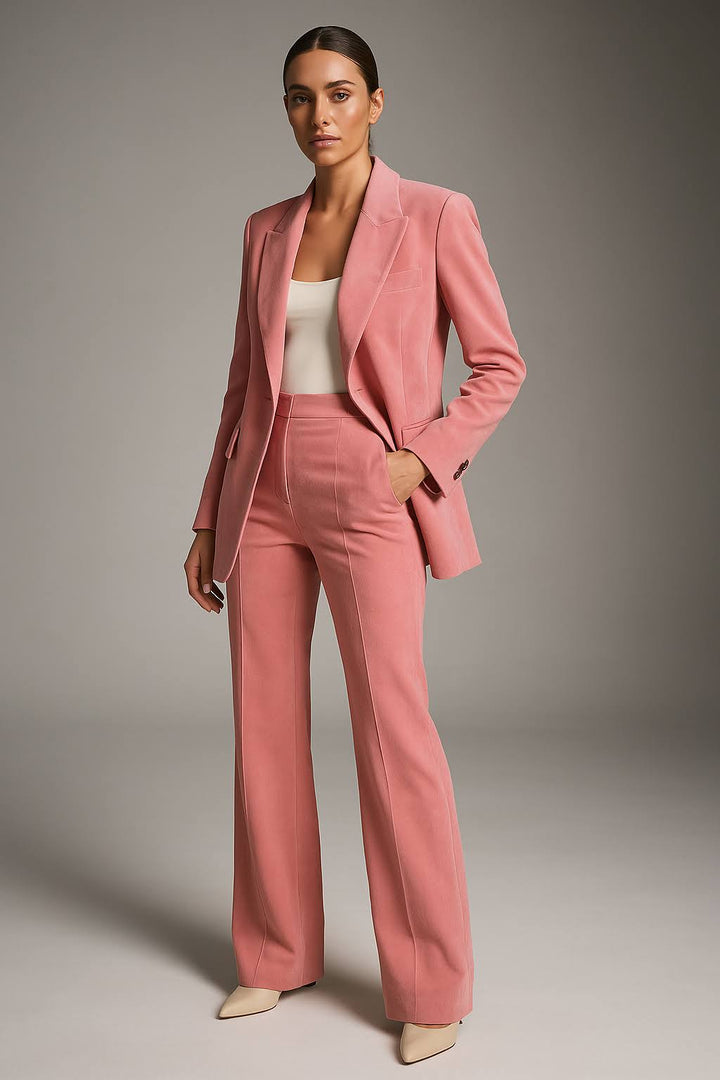 Woman wearing a two-piece trouser suit with fitted blazer and wide-leg trousers on a plain background.