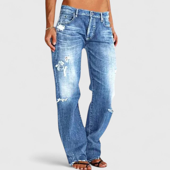 Female model showcasing wide flare jeans with subtle distressed accents.