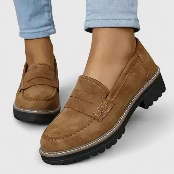 Slip-on loafers for women displayed on a plain background with a classic shape.