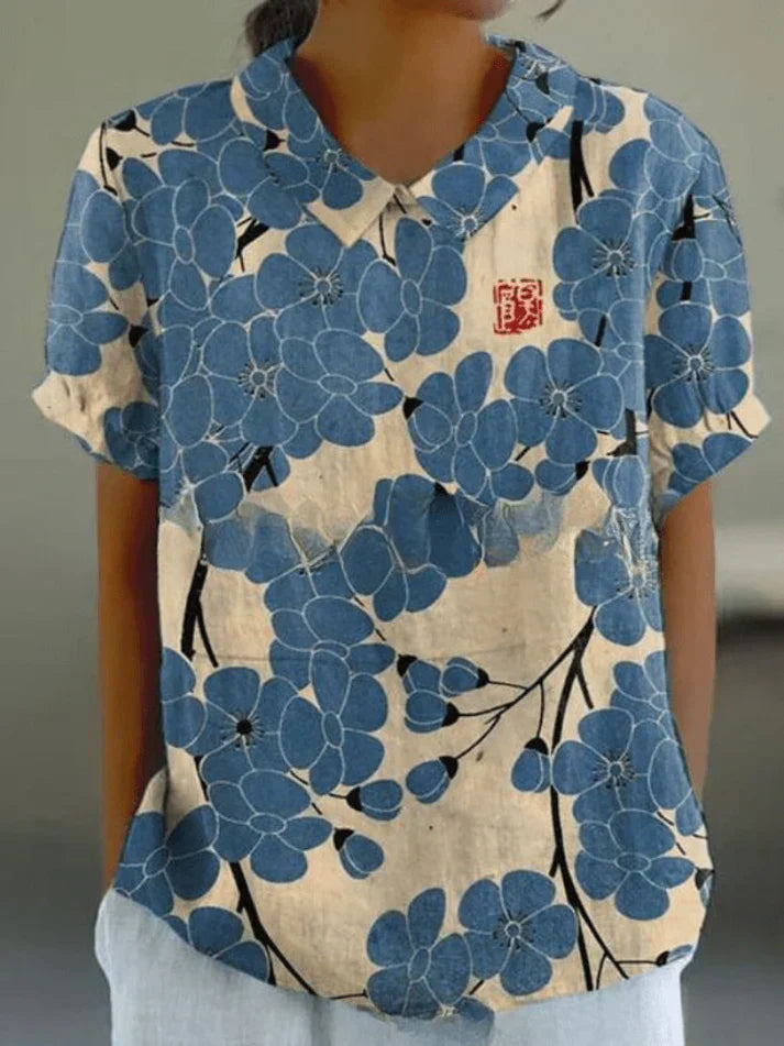 Model in a feminine floral blouse shown on a plain background.