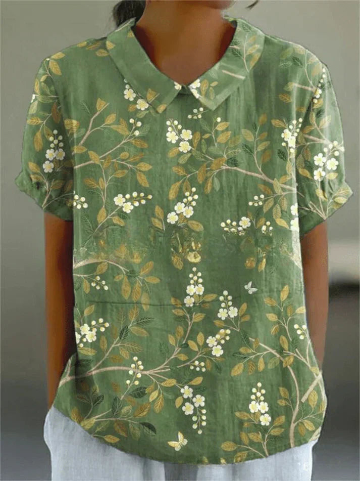 Woman styled in a floral blouse for everyday outfits on a plain background.