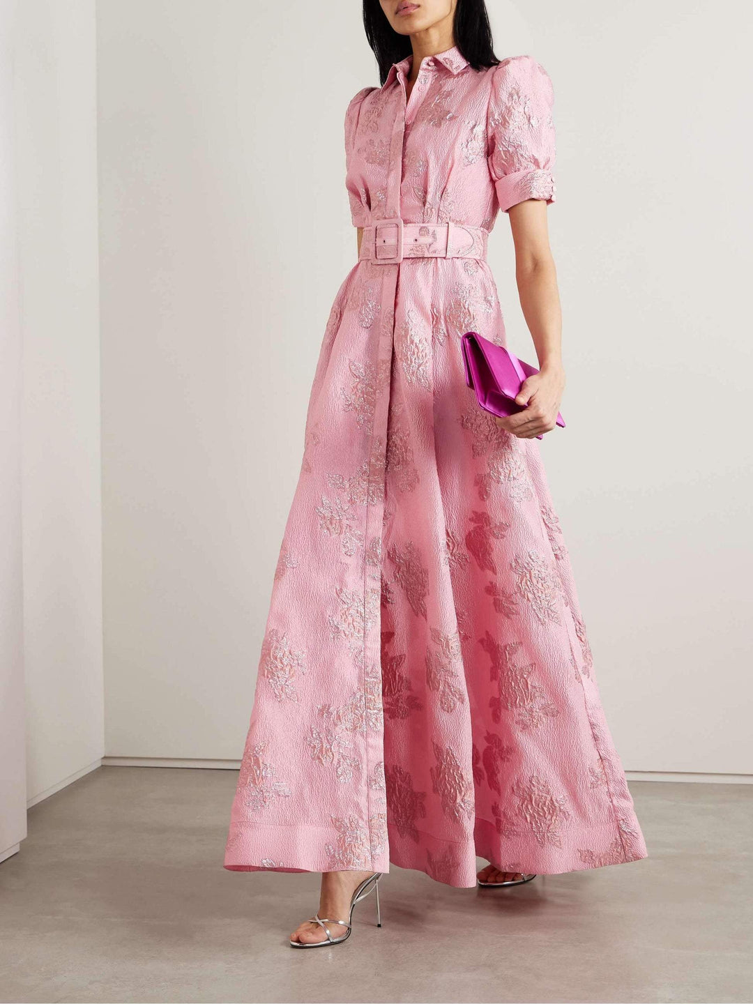 Woman wearing a belted midi dress with a classic feminine silhouette.