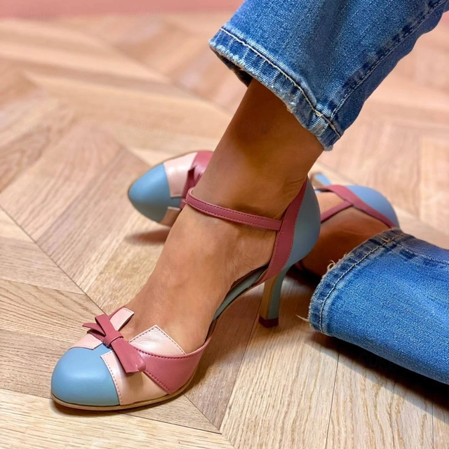 Woman wearing elegant open-toe heeled sandals on a plain background.