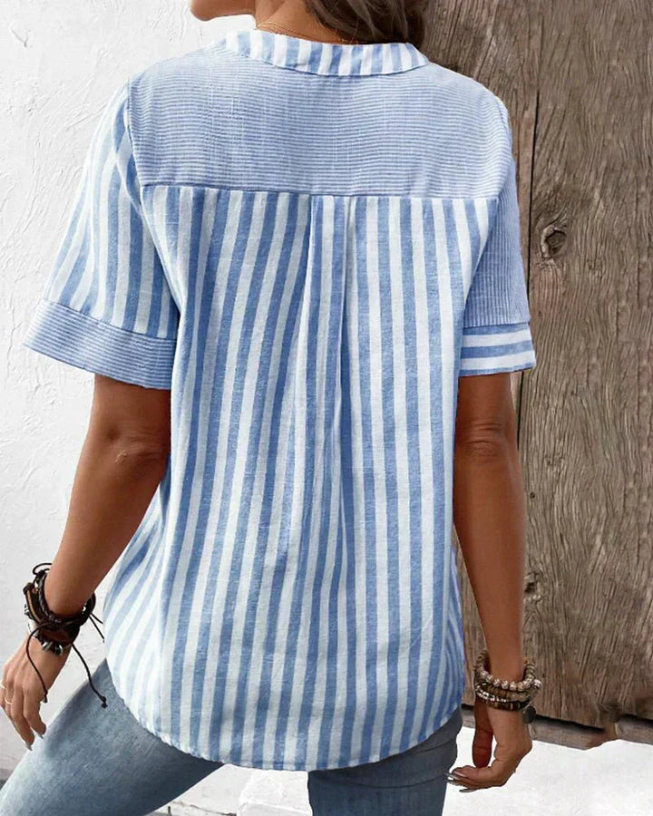  Woman wearing a flowing striped blouse with a relaxed silhouette.