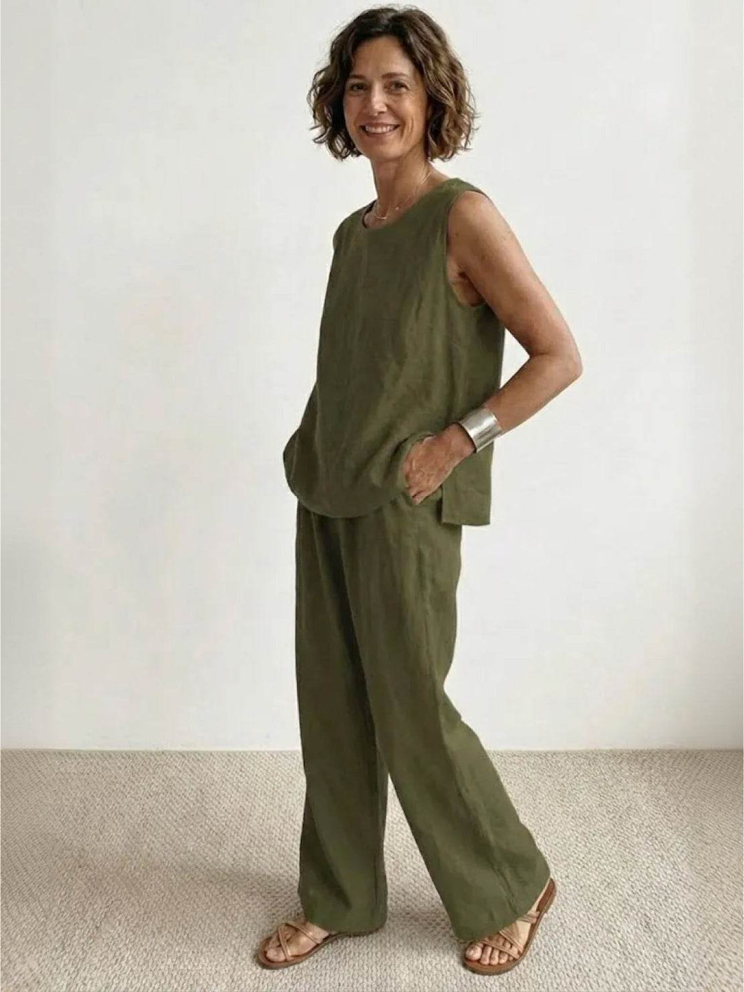 Woman in a matching sleeveless co-ord set featuring relaxed trousers on a plain background.