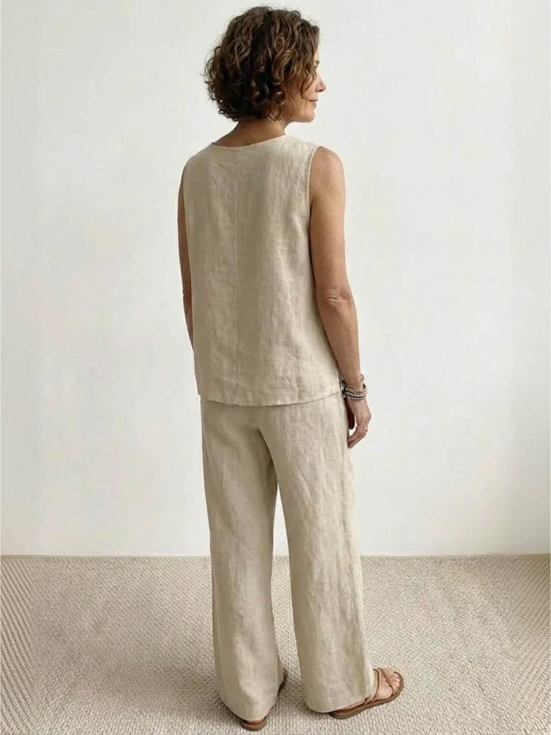  Woman wearing a solid-colour two-piece outfit with a sleeveless top and flowing trousers. 