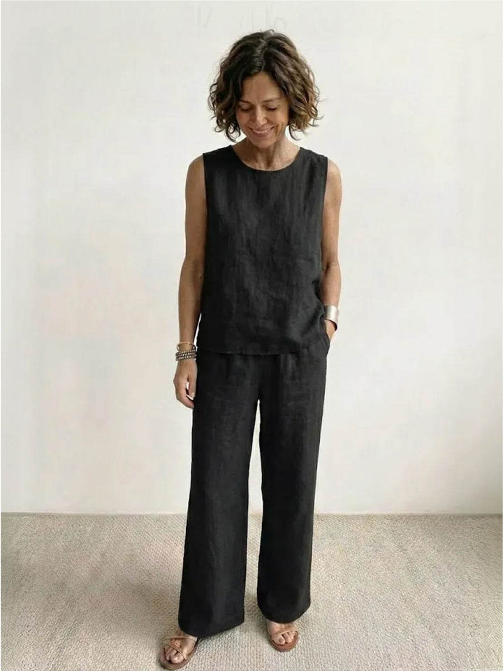  Woman wearing a solid-colour two-piece outfit with a sleeveless top and flowing trousers.