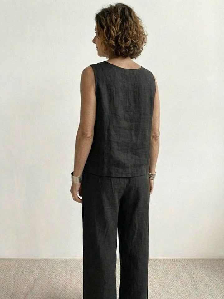 Female model in a coordinated sleeveless set with wide-leg trousers against a plain backdrop. 