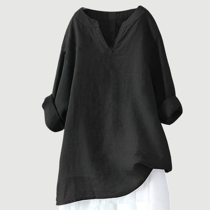 Female model showing a relaxed fit shirt on a plain background.