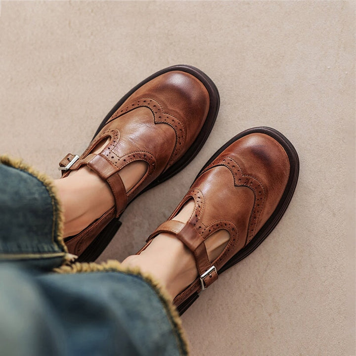 Woman wearing T-strap Mary Jane shoes on a plain background.