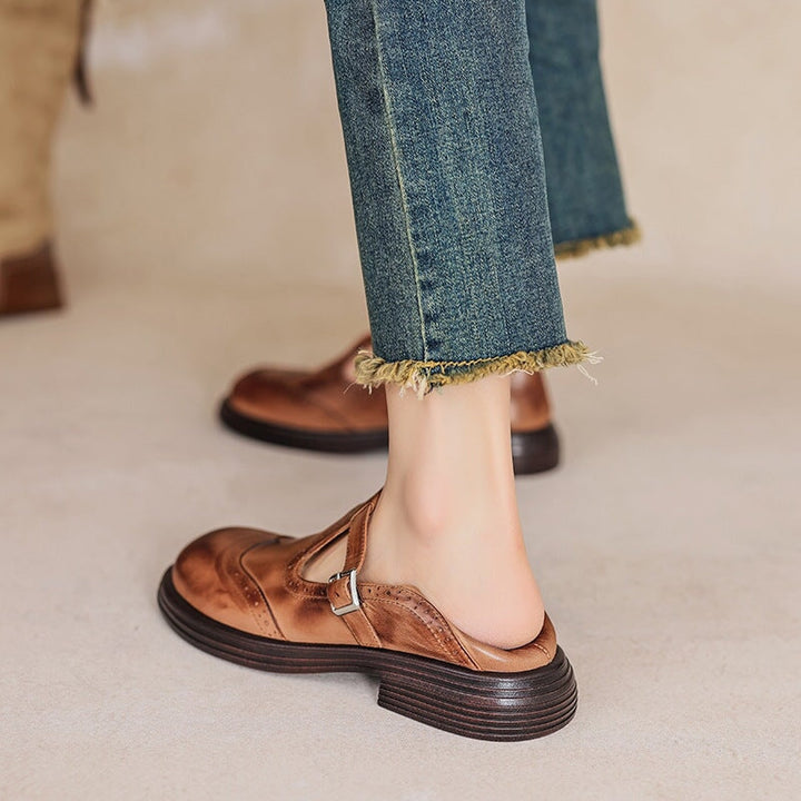 Female model wearing vintage-style T-strap shoes on a plain background.