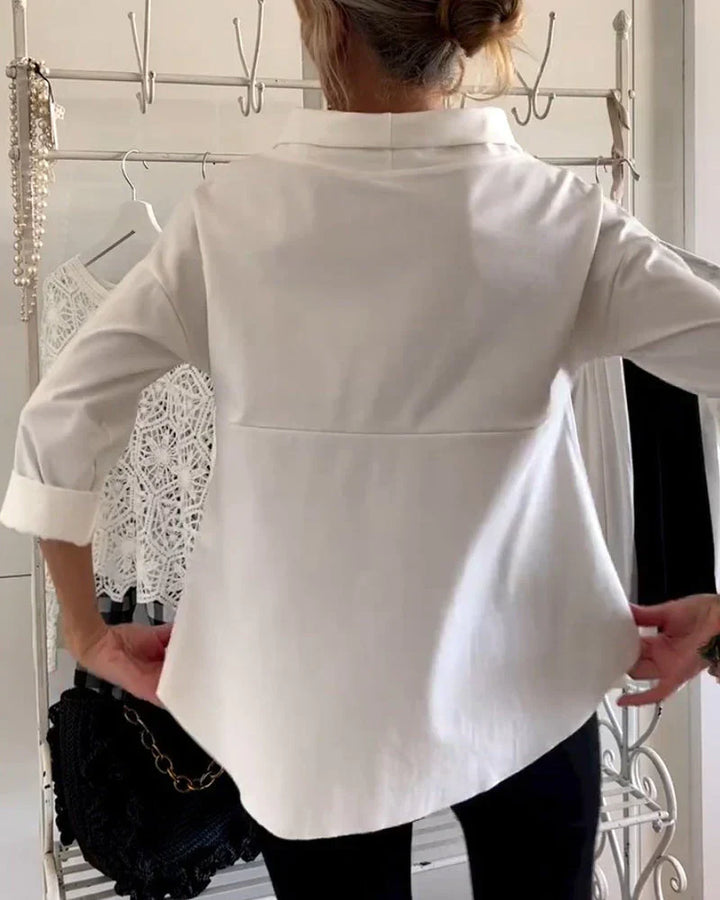  Woman in a casual longline top with three-quarter sleeves on a plain background.