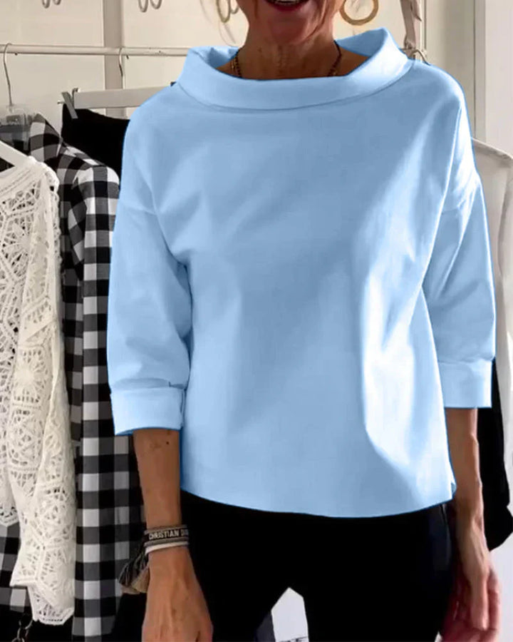 Female wearing a bateau neckline top with a relaxed everyday silhouette.