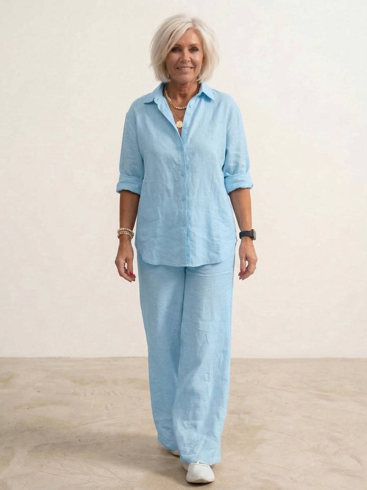 Female model in a matching shirt and wide-leg trousers outfit against a simple backdrop