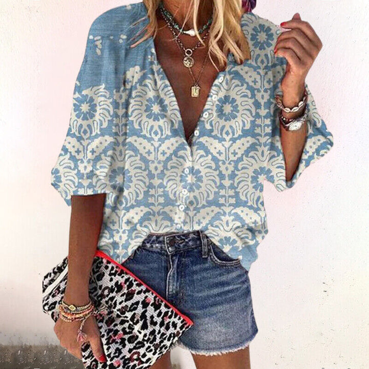  Woman modelling a flowing printed blouse against a plain background.