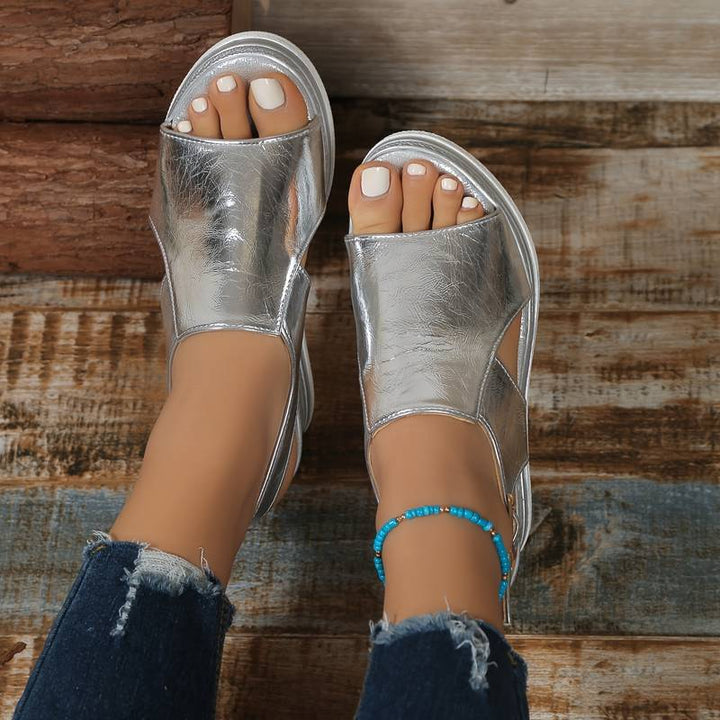 Female model wearing breathable strap sandals with a shiny star finish.