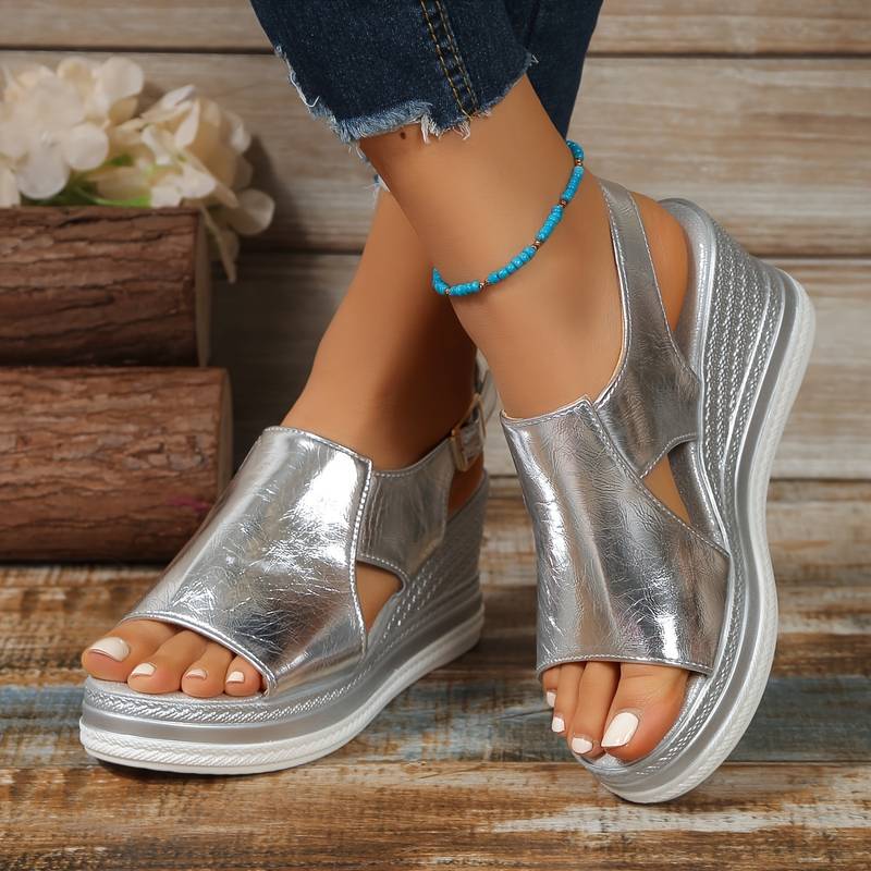 Female model wearing shiny star-pattern sandals on a plain background.