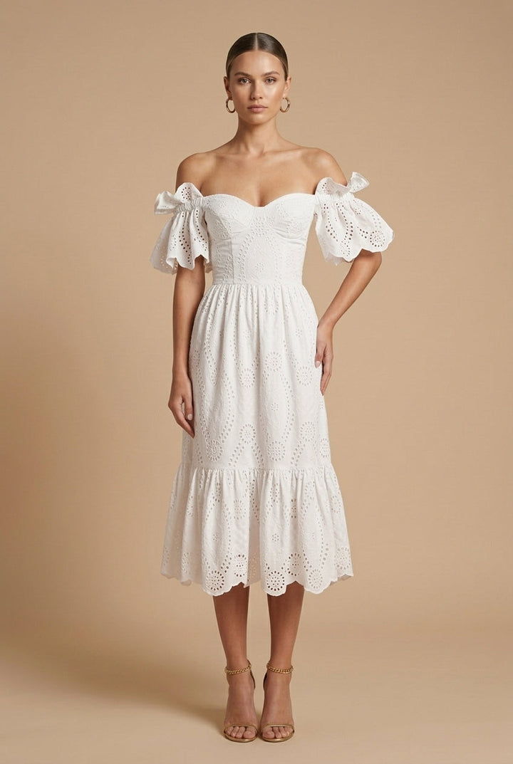  Woman in a formal dress featuring button accents and a structured design on a plain background.