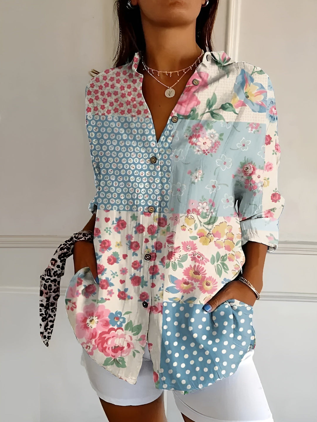 Female model showcasing a vibrant floral printed blouse against a plain background.