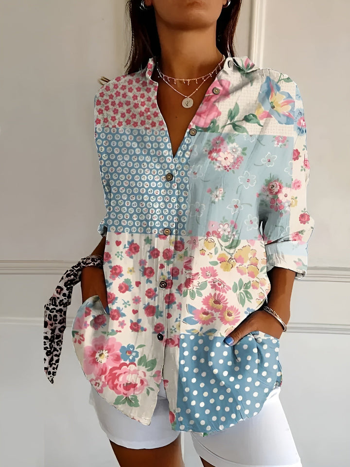 Female model showcasing a vibrant floral printed blouse against a plain background.