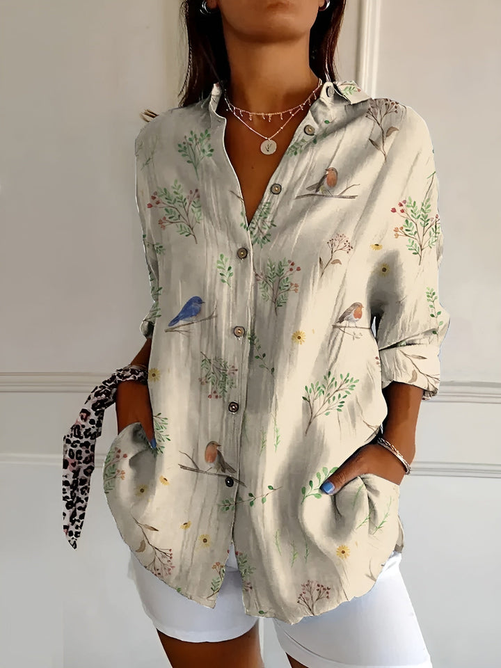 Female dressed in a lightweight floral blouse styled for casual summer wear on a plain background.