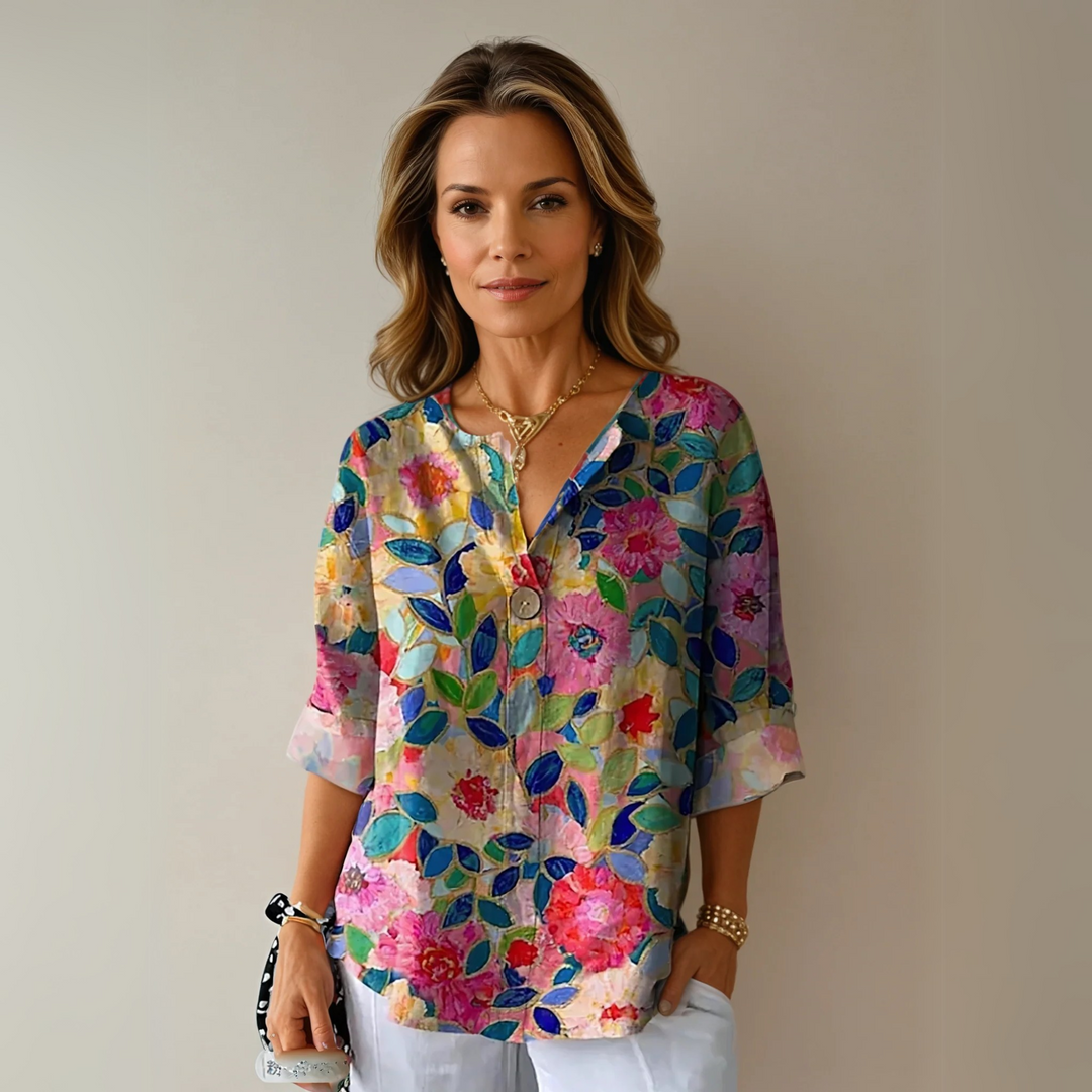 Woman wearing a floral blouse with a relaxed fit against a plain background.