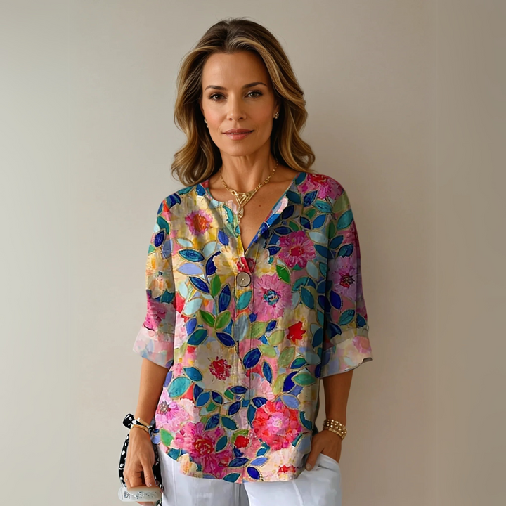 Woman wearing a floral blouse with a relaxed fit against a plain background.