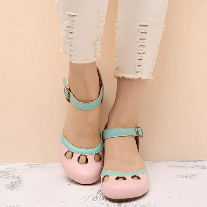 Woman displaying everyday sandals against a plain background.
