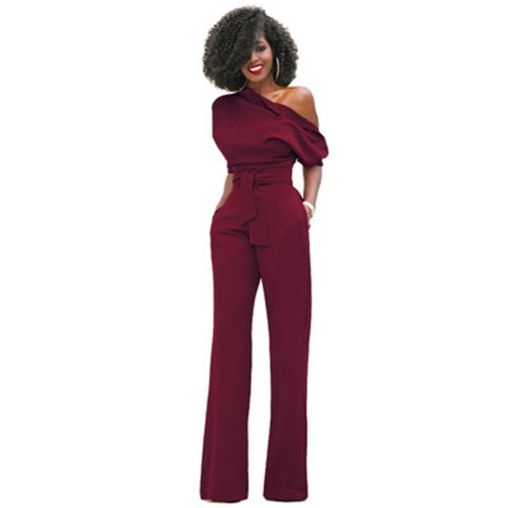 Female model wearing a statement wide-leg jumpsuit on a plain background.