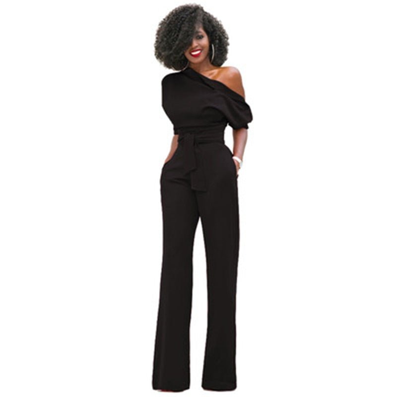 Female model wearing a one-shoulder wide-leg jumpsuit on a plain background.