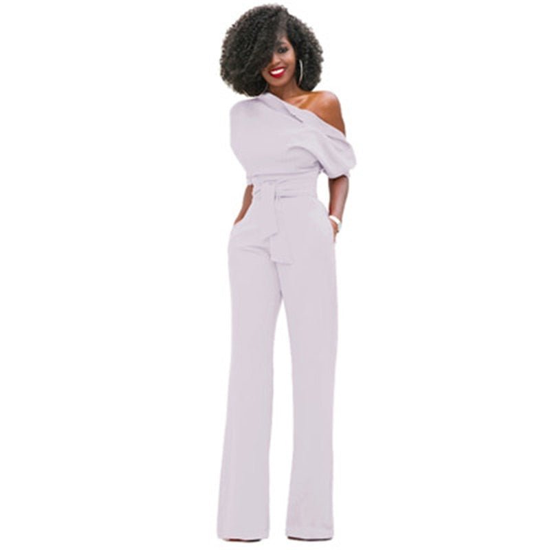 Woman wearing a full-length wide-leg jumpsuit with a shaped waist on a plain background.